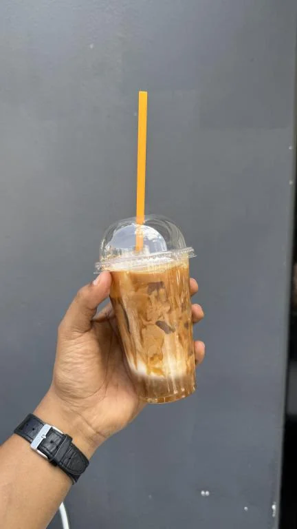 Iced latte to go, held in hand