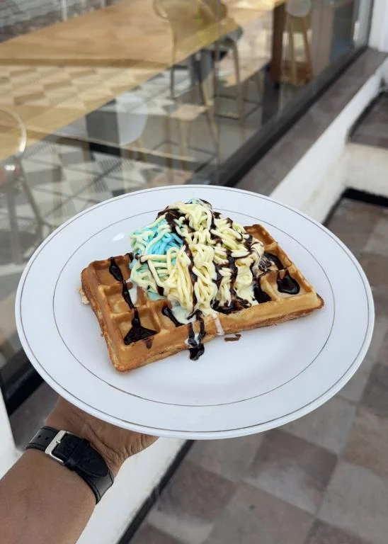 Waffle topped with ice cream and chocolate
