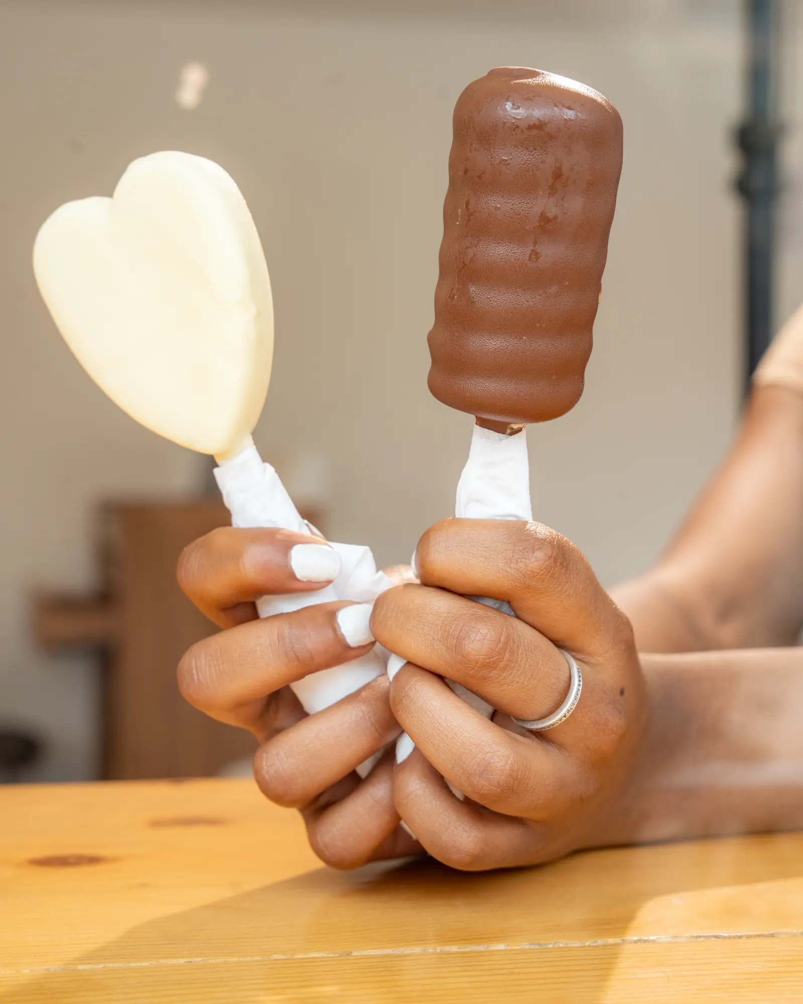 A heart-shaped white chocolate bar and a milk chocolate bar, held side by side