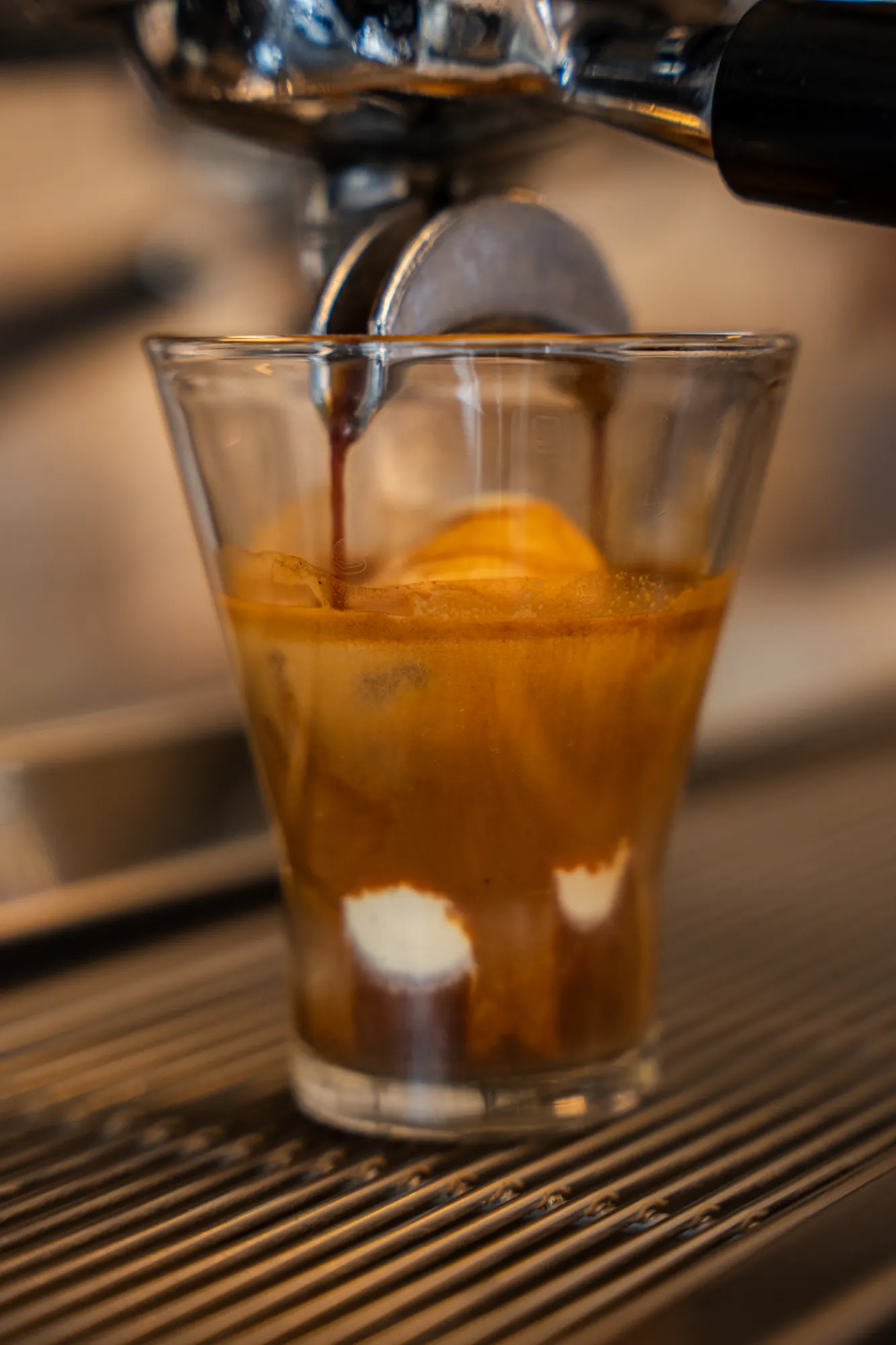 Espresso pouring over ice cream in a glass
