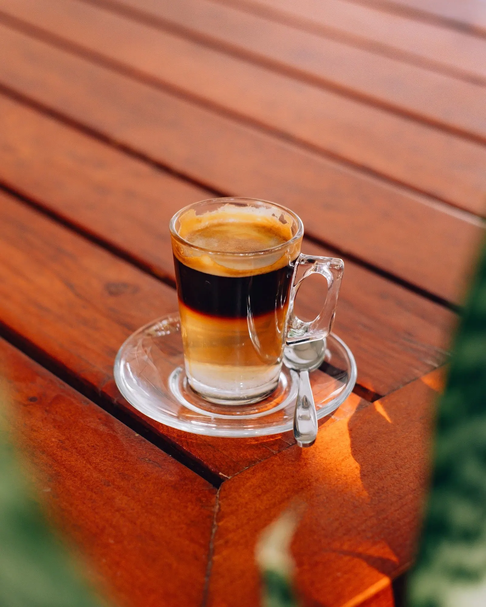 Layered macchiato in a glass cup and saucer