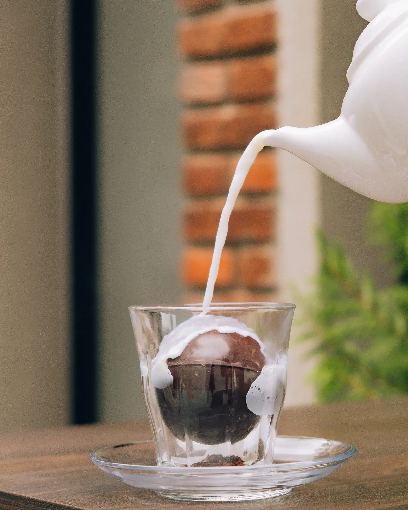 Milk poured over iced coffee at the table