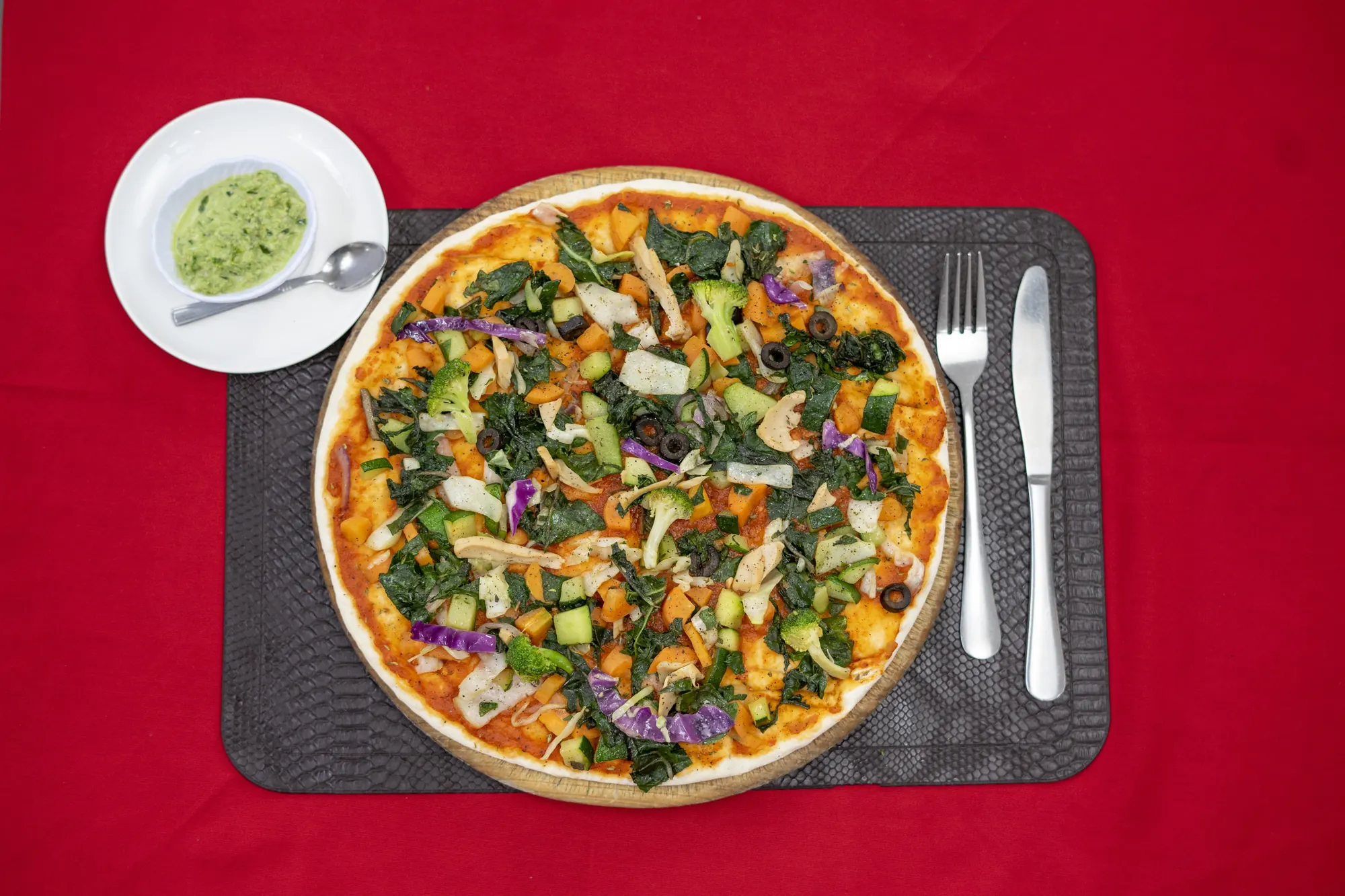 Vegetable pizza with a side of avocado dip