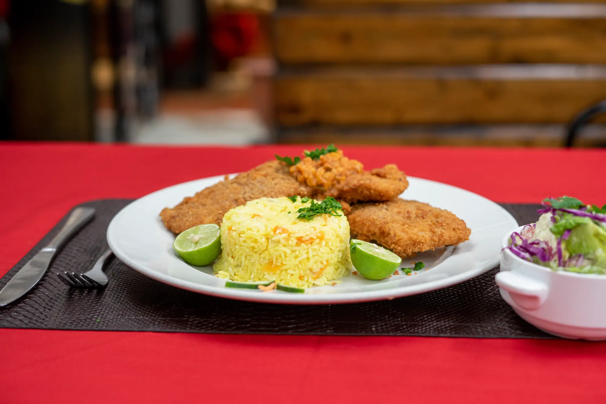 Breaded cutlet with saffron rice, lime and side salad