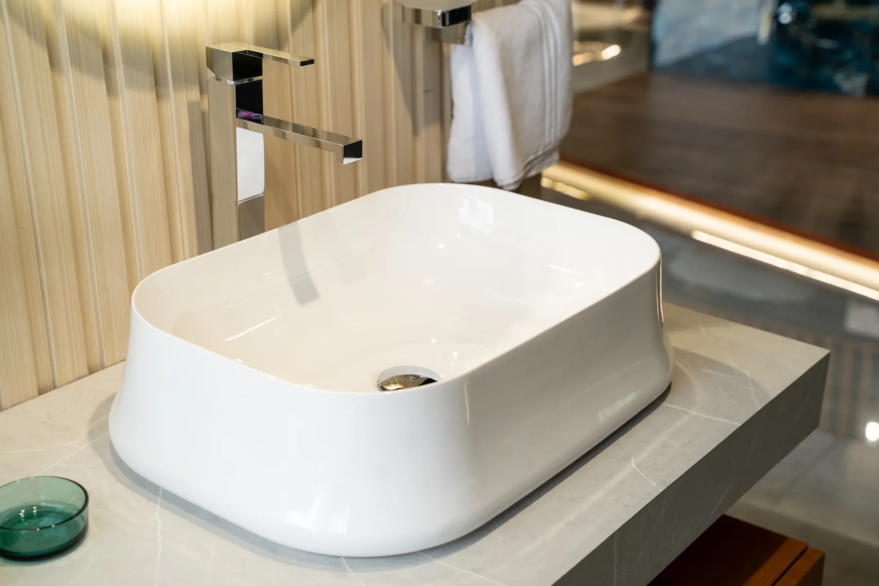 A soft-edged vessel basin with a tall faucet