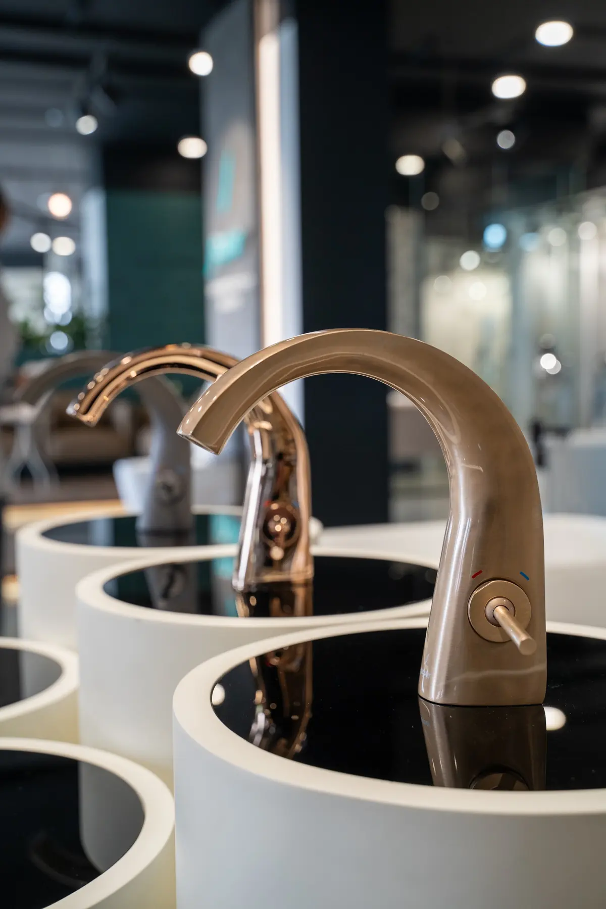 A rose gold faucet over a round basin