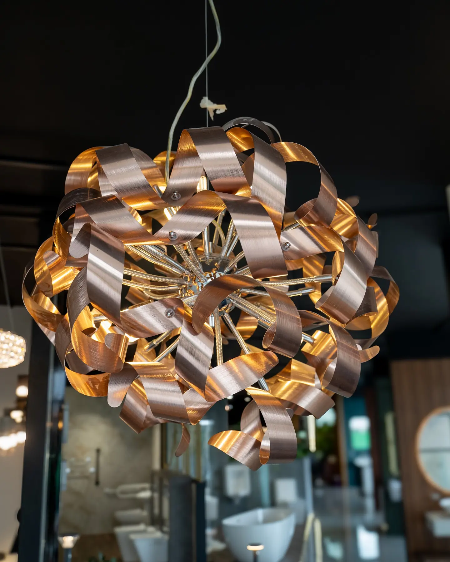 A pendant of twisted copper ribbons, lit from within