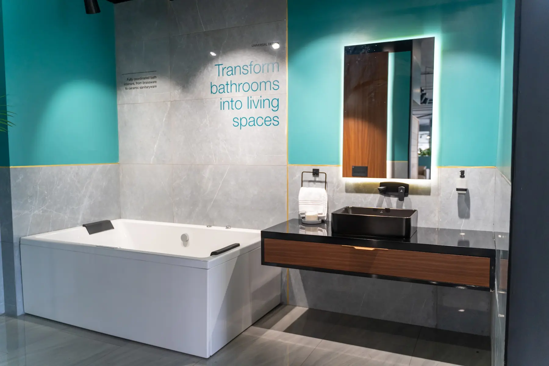 A bathtub and vanity set against a teal wall