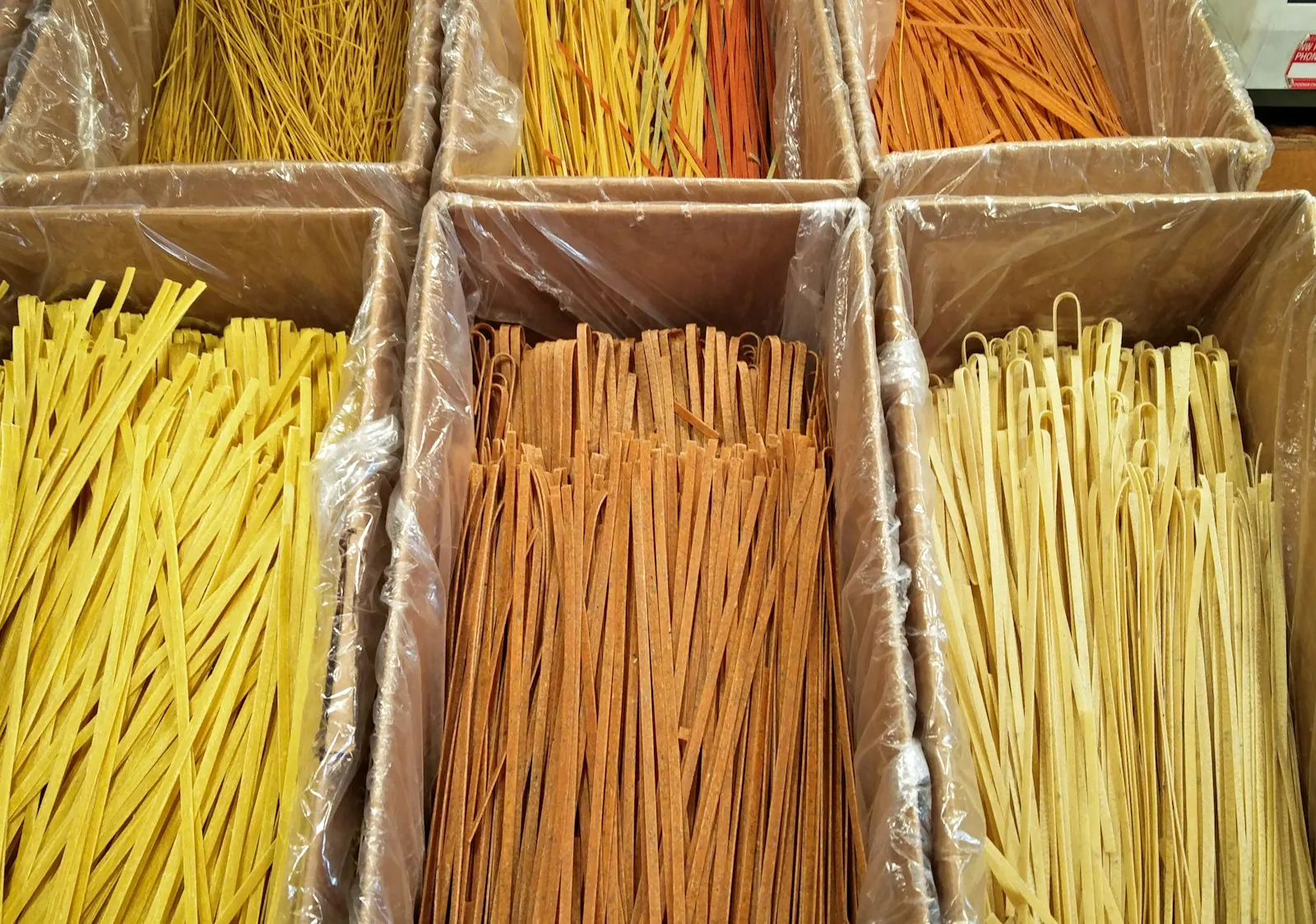 Bins of long dried pasta in several varieties